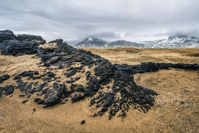 Scenic view of mountains against cloudy sky