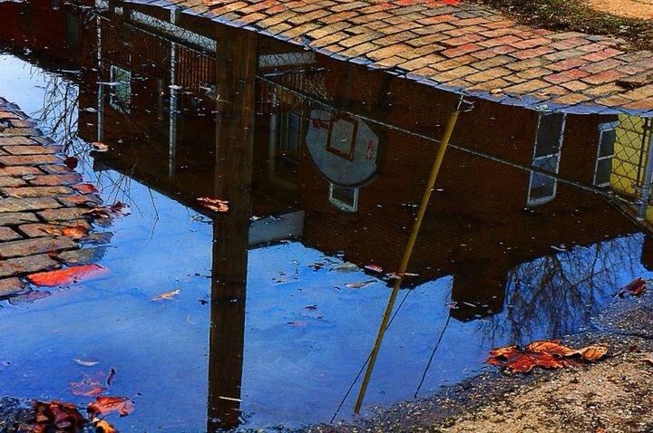 built structure, architecture, reflection, water, building exterior, puddle, day, graffiti, outdoors, wall - building feature, no people, abandoned, weathered, building, standing water, damaged, wet, high angle view, sky, blue