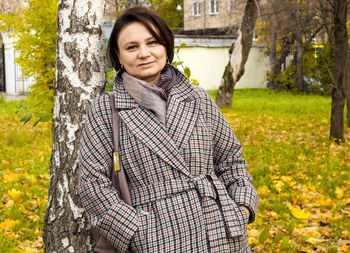 Portrait of smiling woman standing against plants