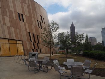 Empty chairs and table against buildings in city