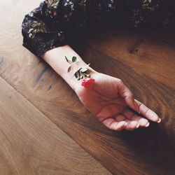 High angle view of woman with rose and bandage on hand