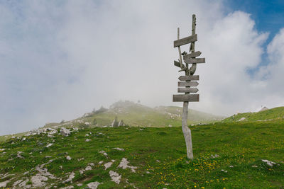 Cross sign on mountain against sky