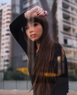 Portrait of young woman standing in city