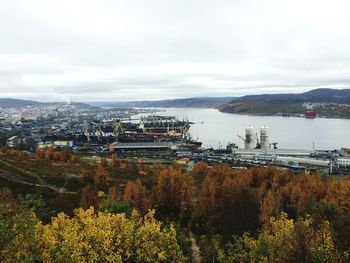 Scenic view of sea by city against cloudy sky