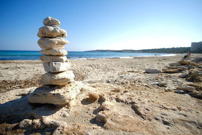 Stack of rocks on beach against clear sky