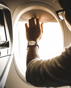 Close-up of man closing airplane window