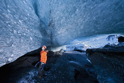 Woman exploring glacier cave at sólheimajökull glacier in iceland