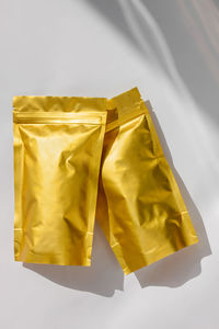 High angle view of yellow paper against white background