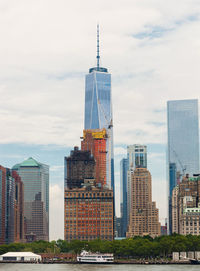 Modern buildings in city against cloudy sky