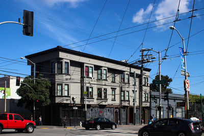 Cars on road by buildings against sky