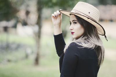 Portrait of beautiful young woman wearing hat