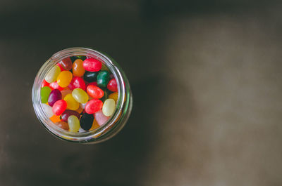 Directly above shot of colorful candies in jar on table