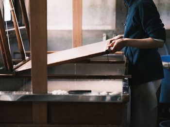 Midsection of man working at workshop