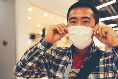 Portrait of man wearing mask in shopping mall