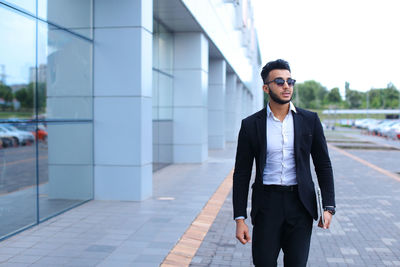 Portrait of businessman standing against building