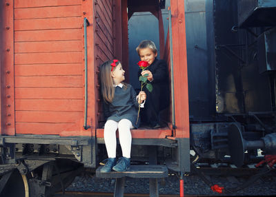 Full length portrait of woman sitting on train