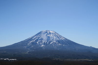 Scenic view of snowcapped mountains against clear blue sky