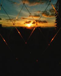 Close-up of illuminated silhouette against sky during sunset