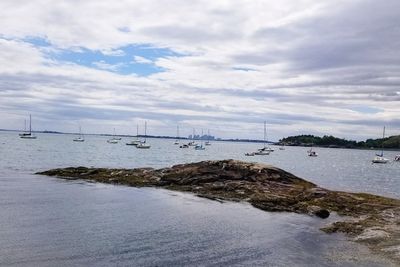 Sailboat on sea shore against sky