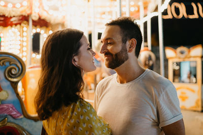 Romantic couple standing by carousel