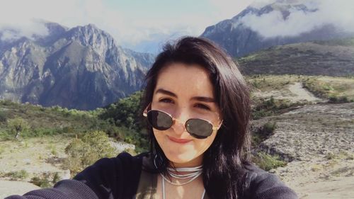 Portrait of woman standing on field against mountain