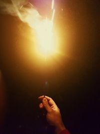 Midsection of person holding illuminated light at night