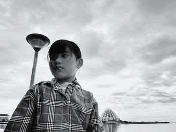 Girl looking away against sky