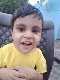 Portrait of smiling boy sitting outdoors