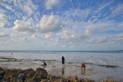 People on beach against sky