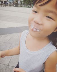 Close-up portrait of smiling girl on footpath