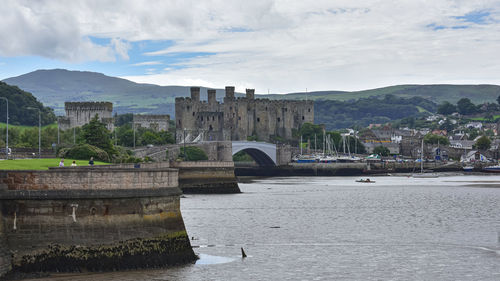 Bridge over river against cloudy sky