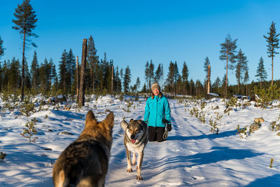 View of woman with dog on snow covered land