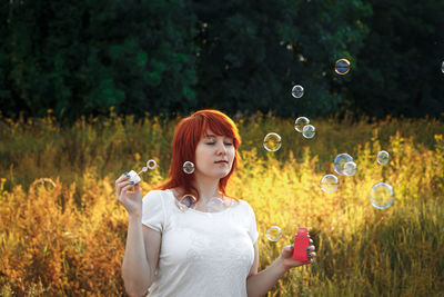 Portrait of young woman blowing bubbles