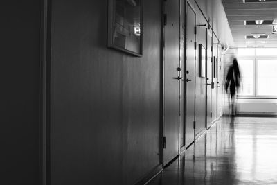 Blurred motion of woman walking in corridor of building