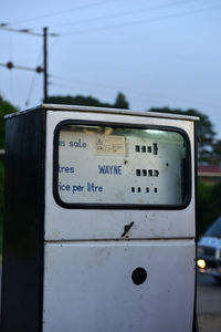 Close-up of information sign against sky