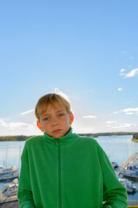 Portrait of boy standing in sea against sky