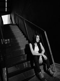 Full length of woman sitting on staircase