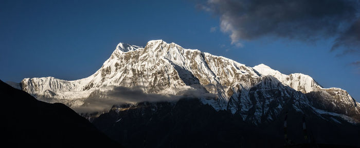 Low angle view of snowcapped mountains against sky