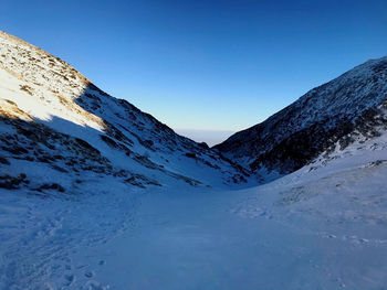 Scenic view of snowcapped mountains against clear blue sky