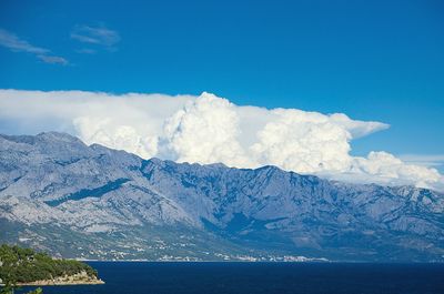 Scenic view of snowcapped mountains against blue sky