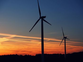 Wind turbines in field at sunset