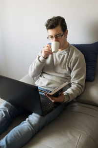 Portrait of boy using laptop while sitting on sofa at home
