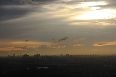 Silhouette buildings in city against sky during sunset