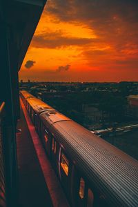 Train on bridge against sky during sunset