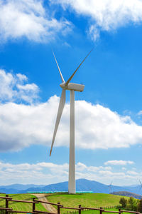 Low angle view of windmill on field against sky