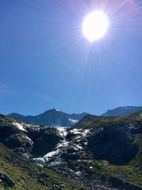 Scenic view of mountains against sky on sunny day