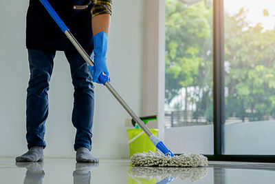 Low section of man cleaning floor