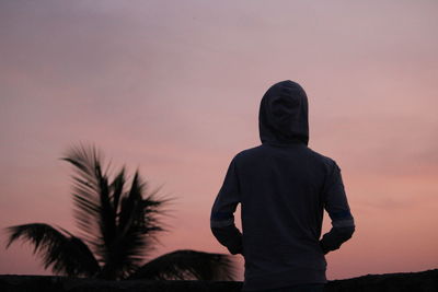 Rear view of silhouette man looking at sunset