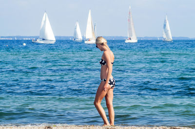 Full length of woman wearing bikini against sea