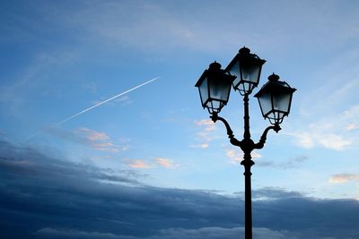 Low angle view of street light against blue sky